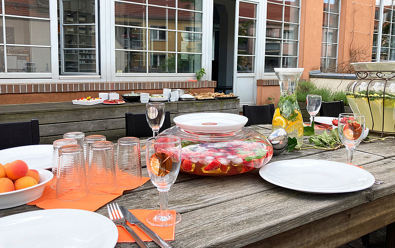 Das Bild zeigt eine Nahansicht auf das Buffet zu unserer Feier. Viele Details wie Servietten, Gerichte, etc. sind in Orange, unserer Hausfarbe gehalten.