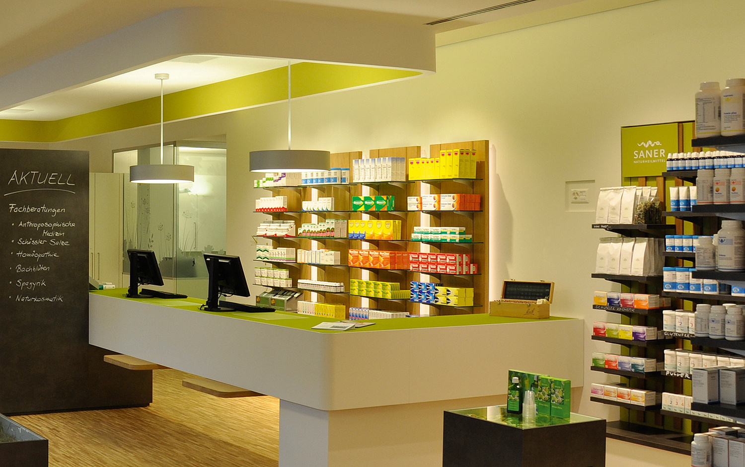 Innenarchitektur Saner Apotheke Sicht in der Verkaufsbereich mit Theke und Regalen (© Papenfuss | Atelier)