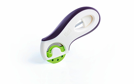 Rollschneider prym.ergonomics mit gesicherter Schneidklinge und dem verliersicher eingeklickten Wechselwerkzeug im ergonomisch geformten Griff.