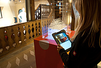 Miniaturmodell des Hauses und Besucherin mit Tablet