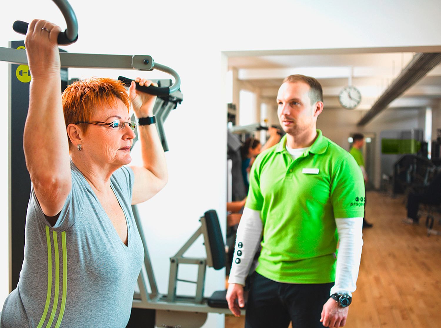 Imagefotografie – People-Fotografie: Betreuung an Trainingsgerät Imagefotografie: Szene an Trainingsgerät. Kunde mit progesund-Mitarbeiter (© Papenfuss | Atelier)