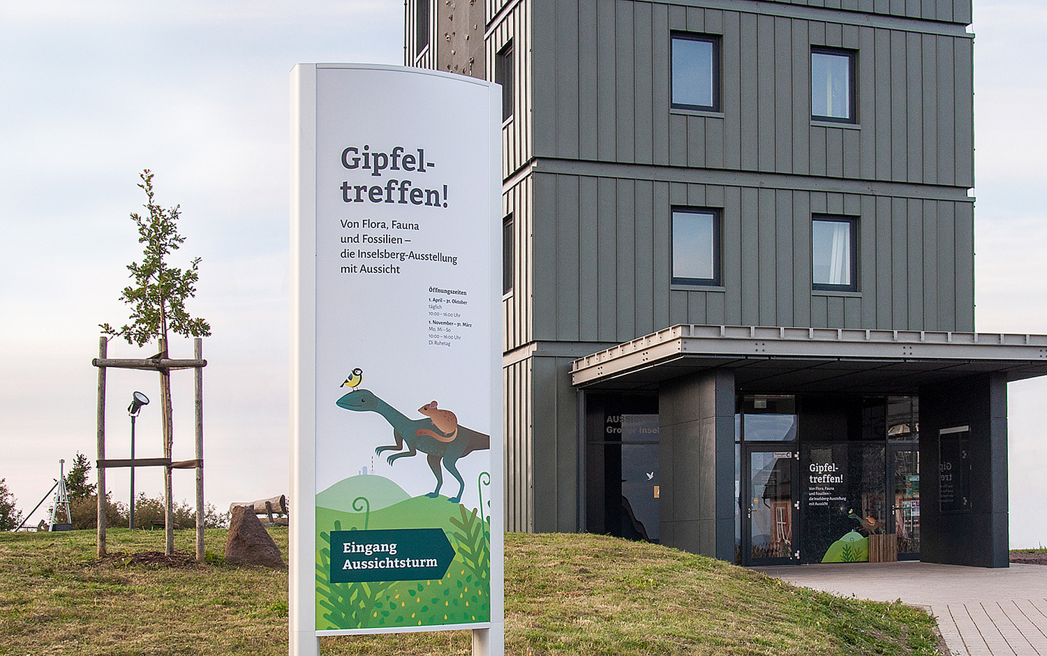 Blick auf den Eingangsbereich zur Ausstellung mit Pylon und Fensterfassade als "Anlocker"  (© Papenfuss | Atelier)