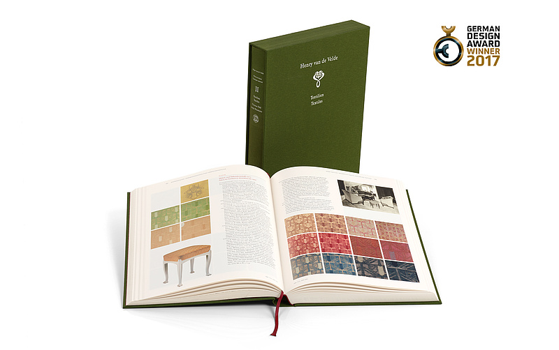 Gewinner German Design Award 2017 Werkverzeichnis Henry van de Velde Band II Textilien Klassik Stiftung Weimar Werkverzeichnis Henry van de Velde Band 2 Textilien aufgeschlagen und Schuber stehend sowie Gewinnerlogo German Design Award 2017