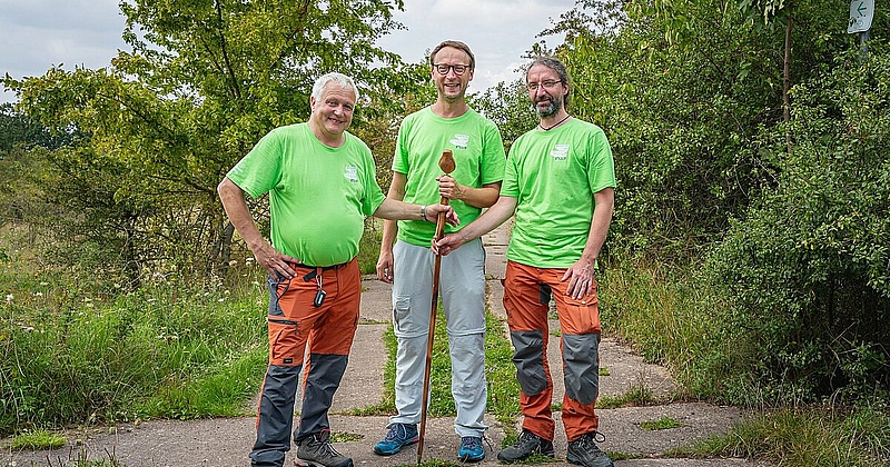 Dennis Peisker (Mitte), Leiter der Stiftung Naturschutz Thüringen, und die beiden Gebietsbetreuer Gerhard Propf (links) und Stefan Sander (rechts) bei der Übergabe des Wanderstabs.